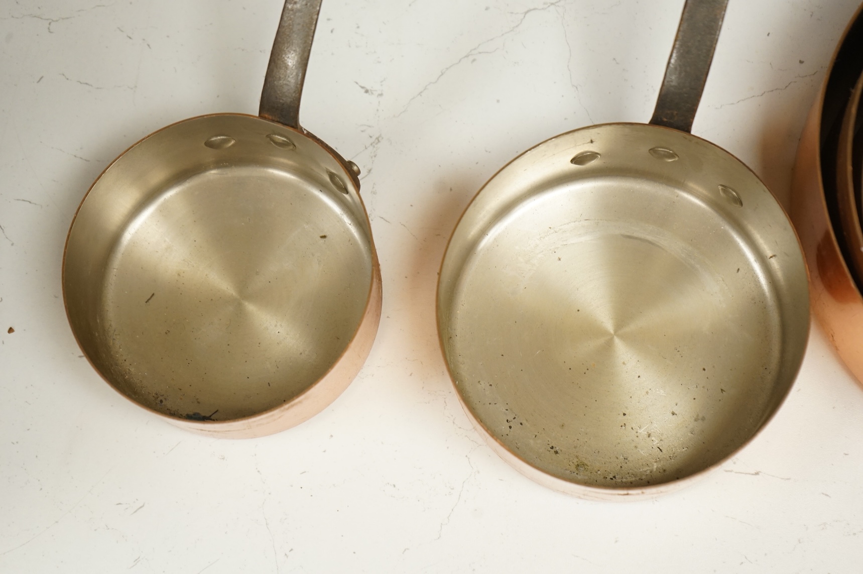 A graduated set of six French Tournus copper cooking pans, largest 44cm wide
